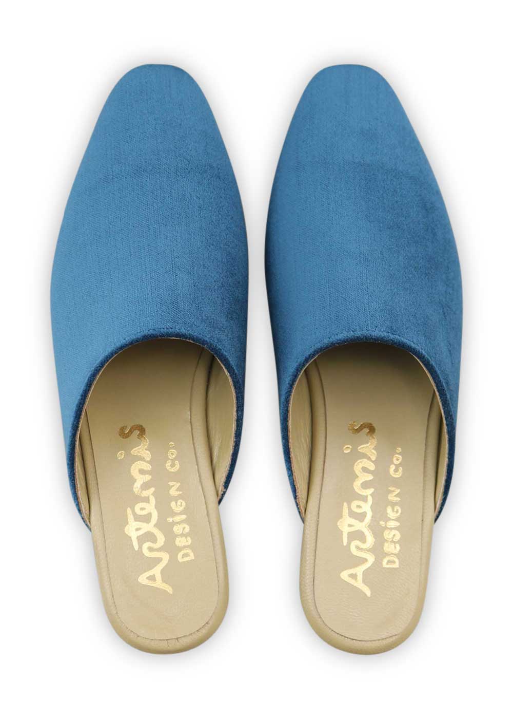 Artemis Design Co's Women's Velvet Mules in teal offer a luxurious and elegant footwear option. Crafted with plush velvet material in a stunning teal hue, these mules combine comfort with sophistication. With a sleek silhouette and a timeless design, they effortlessly elevate any outfit, whether for a casual day out or a special occasion. (Front View)