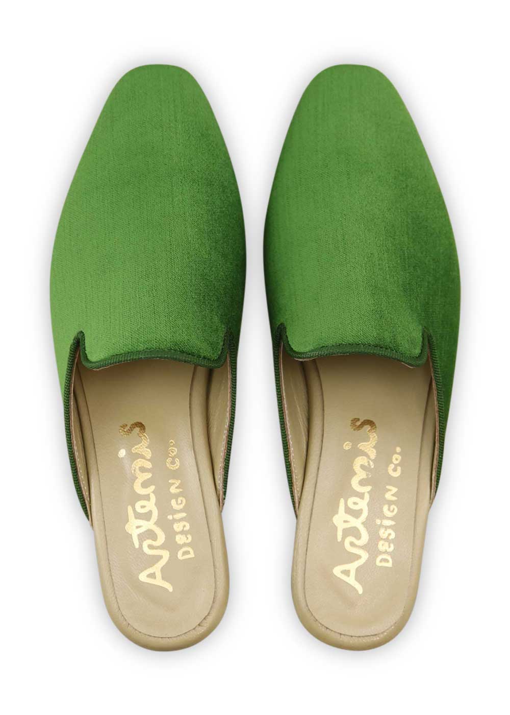 Artemis Design Co's Women's Velvet Mules in green are a stylish and chic footwear choice. Made from sumptuous velvet fabric in a rich green shade, these mules exude opulence and refinement. Their classic design features a comfortable fit and a sleek silhouette, making them versatile for both everyday wear and formal occasions. Add a touch of sophistication to your ensemble with these luxurious green velvet mules from Artemis Design Co. (Front View)