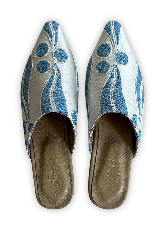 Introducing Artemis Design Co Women's Babouches in a crisp and refreshing color combination of blue and white. These meticulously crafted babouches seamlessly blend classic hues for an effortlessly chic look. Perfect for both casual outings and special occasions, they offer a stylish yet comfortable option for every day. Elevate your footwear collection with Artemis Design Co Women's Babouches, embodying timeless elegance in a modern palette of blue and white. (Front View)