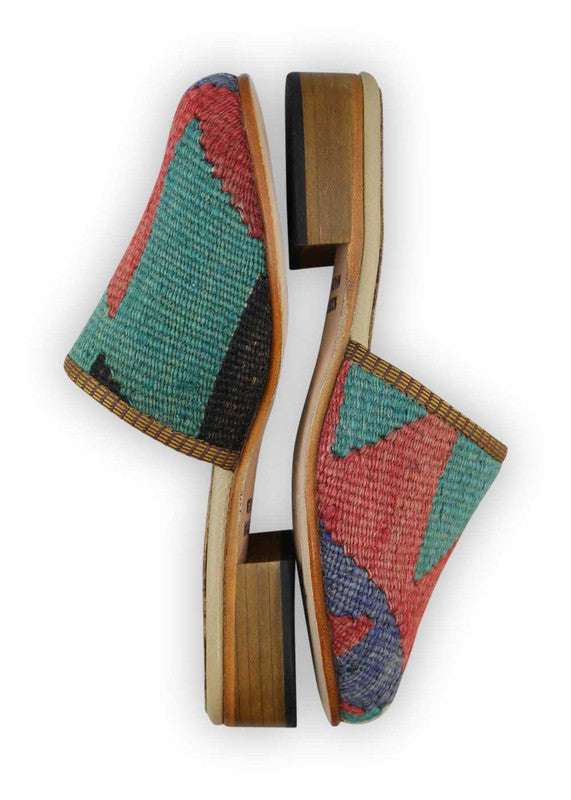 The Artemis Women's Slides exhibit an alluring color combination of red, teal, blue, and black. These slides bring together a striking mix of vibrant and classic hues, resulting in a chic and versatile appearance. (Side View)