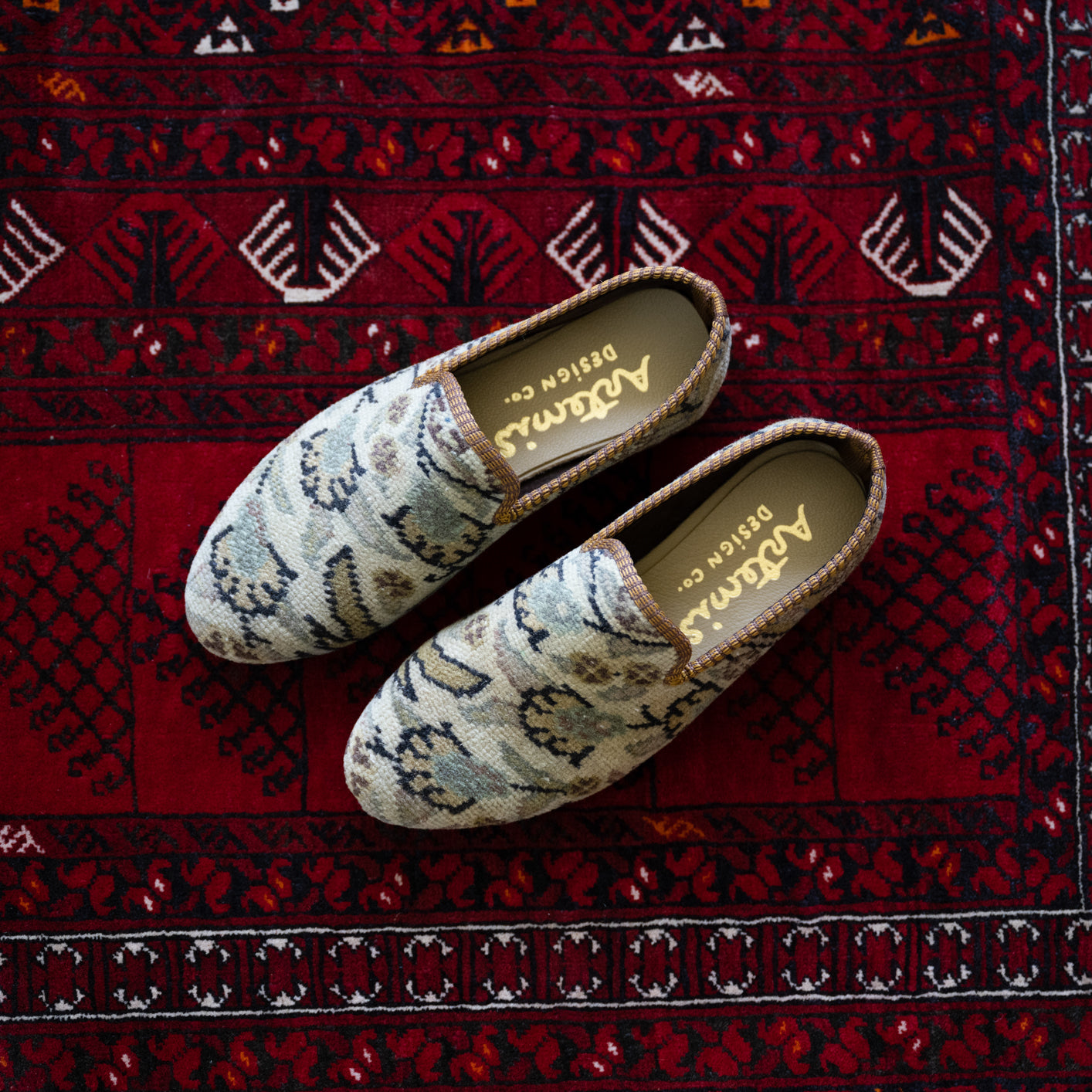 Men's carpet loafers on a red oriental carpet