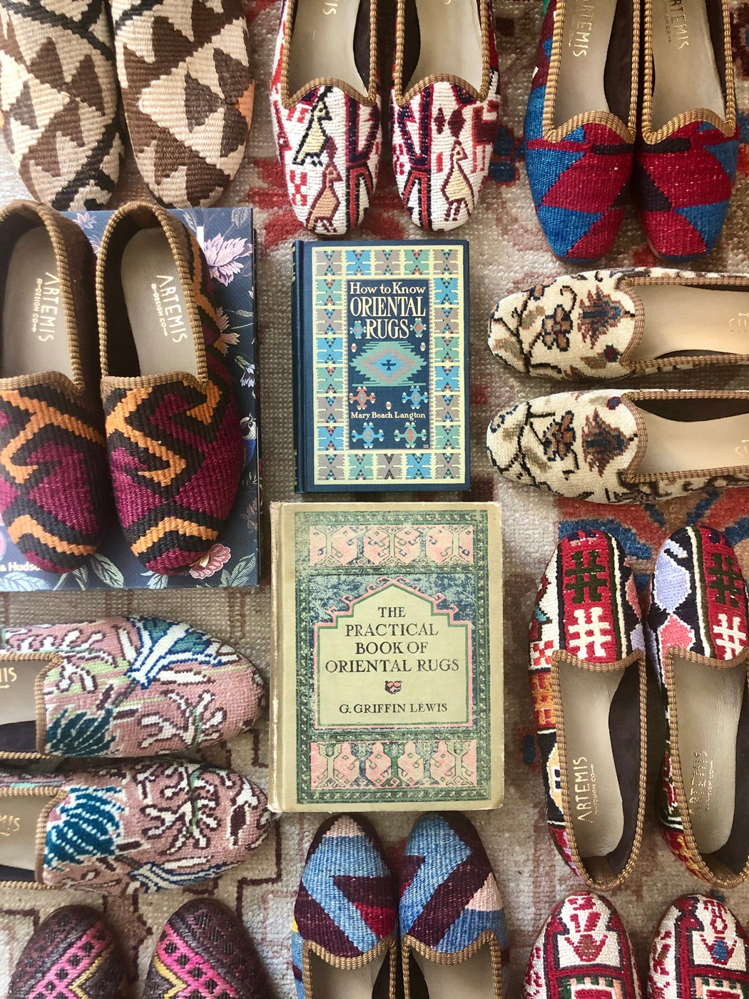 kilim shoes arranged around antique books about textile art