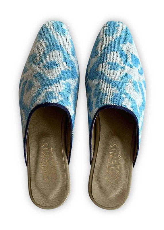 Introducing Artemis Design Co Women's Mules in a timeless color combination of blue and white. These meticulously crafted mules effortlessly blend classic hues for an elegant yet versatile look. Whether you're dressing up for a special occasion or adding a touch of sophistication to your everyday ensemble, these mules offer both style and comfort. Elevate your wardrobe with Artemis Design Co Women's Mules, epitomizing understated elegance in a refined palette of blue and white. (Front View)