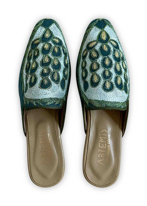Introducing Artemis Design Co Women's Mules in a captivating color combination of teal, light blue, green, and khaki. These meticulously crafted mules showcase a harmonious blend of soothing hues, exuding both elegance and comfort. Whether you're strolling through the city streets or attending a brunch with friends, these mules elevate your ensemble with their timeless style and chic design. (Front View)