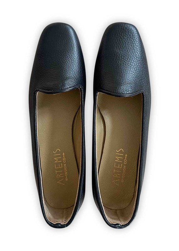 Artemis Design Co's Women's Loafers in black epitomize timeless elegance and versatility. Crafted with meticulous attention to detail, these loafers feature a sleek design and a comfortable fit. The classic black hue offers a sophisticated touch, making them suitable for any occasion, from casual outings to formal events. With their refined silhouette and quality craftsmanship, these loafers are a wardrobe essential that effortlessly complements any ensemble. (Front View)