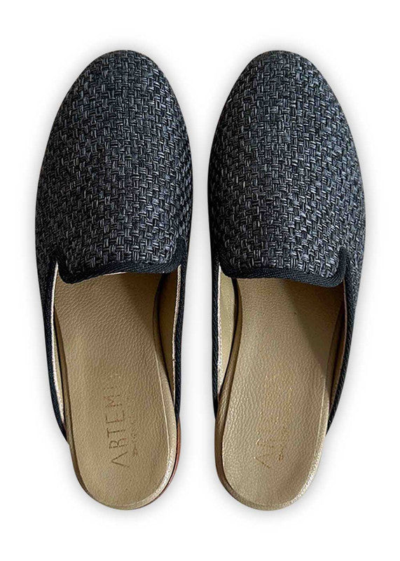 Artemis Design Co's Women's Slippers in charcoal black epitomize refined comfort. These slippers blend luxurious materials with impeccable craftsmanship, providing a plush interior for optimal coziness. The sleek charcoal black exterior exudes timeless sophistication, making them versatile for lounging at home or running quick errands. (Front View)