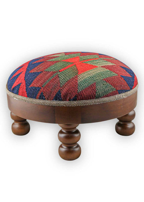  The Artemis Design & Co Footstool is a chic and vibrant accent piece, showcasing a captivating color palette of blue, red, maroon, and grey. Meticulously crafted, this footstool seamlessly blends bold and rich tones, creating a stylish and eye-catching addition to your living space. (Side View)