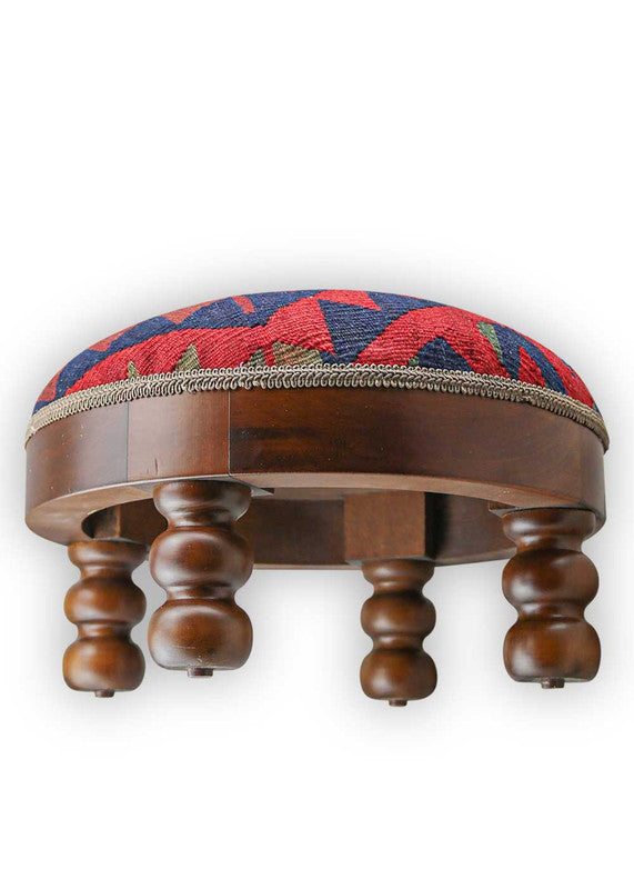  The Artemis Design & Co Footstool is a chic and vibrant accent piece, showcasing a captivating color palette of blue, red, maroon, and grey. Meticulously crafted, this footstool seamlessly blends bold and rich tones, creating a stylish and eye-catching addition to your living space. (Side View)