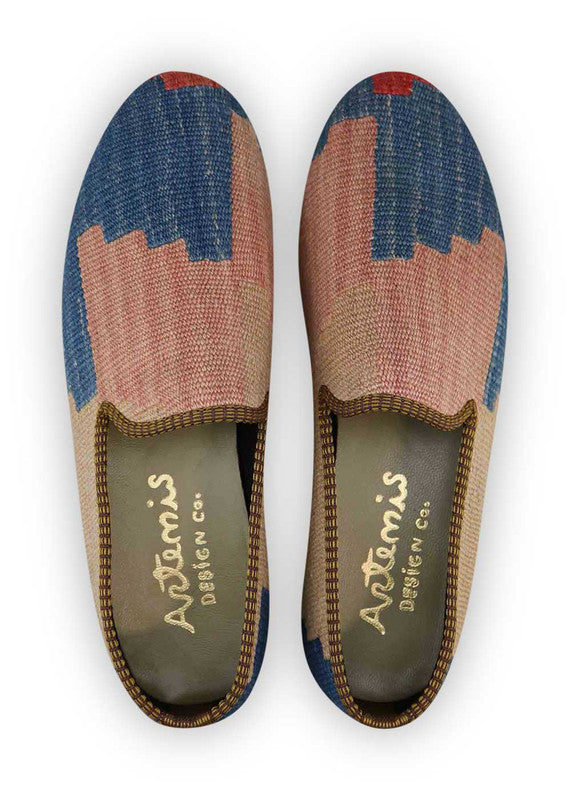 The Artemis Men's Loafers radiate a sense of timeless sophistication, boasting a color palette that harmonizes royal blue, beige, black, and red. These loafers effortlessly merge the boldness of royal blue and red with the neutrality of beige, set against a clean black backdrop. (Front View)