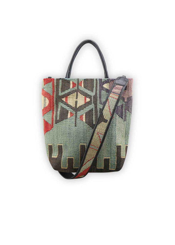 The Artemis Design Co. Sumak Kilim Tote epitomizes contemporary sophistication and style. Crafted from sleek black leather, this tote features a captivating Sumak Kilim pattern adorned with vibrant accents of red, balanced with shades of black, grey, white, and blue. The striking color combination adds a touch of modern flair to the classic design, making it a versatile accessory for any occasion.  (Front View)