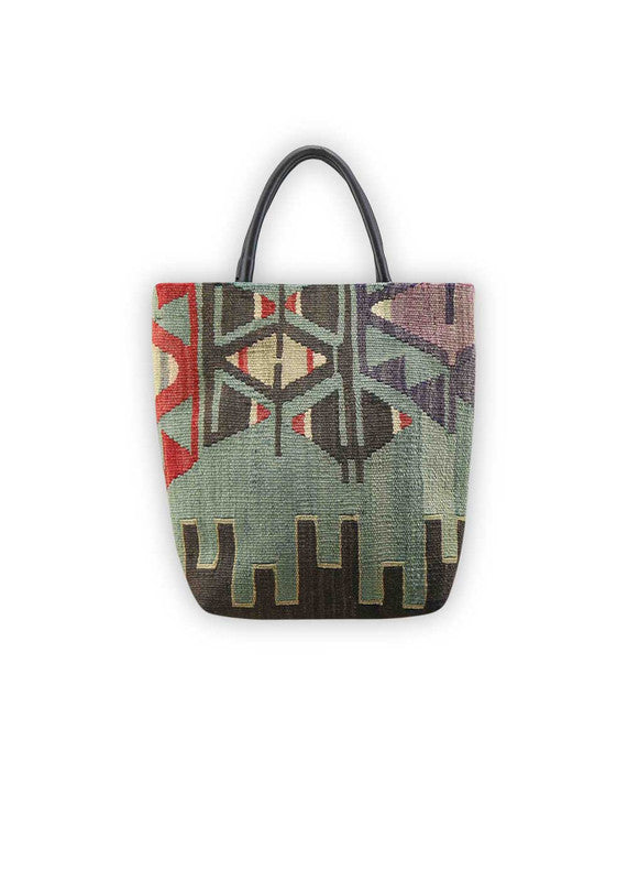 The Artemis Design Co. Sumak Kilim Tote epitomizes contemporary sophistication and style. Crafted from sleek black leather, this tote features a captivating Sumak Kilim pattern adorned with vibrant accents of red, balanced with shades of black, grey, white, and blue. The striking color combination adds a touch of modern flair to the classic design, making it a versatile accessory for any occasion. (Front View)