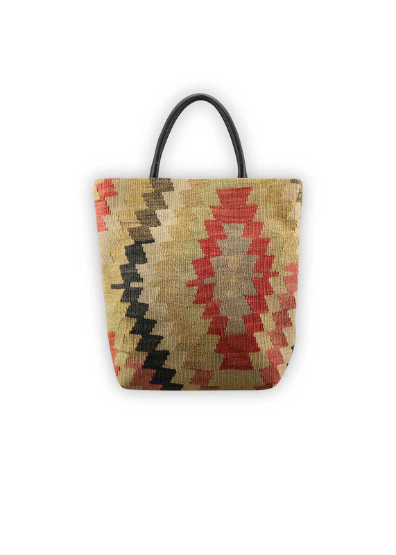 The Artemis Design Co. Sumak Kilim Tote exudes timeless sophistication with a modern twist. Crafted from premium black leather, this tote showcases a stunning Sumak Kilim pattern in a refined palette of red, khaki, black, and beige. The classic combination of colors adds a touch of understated elegance to the bag, making it a versatile accessory for any outfit. (Front View)