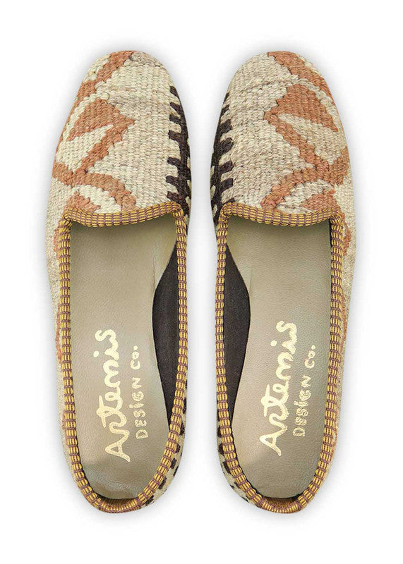 Artemis Design & Co Women's Loafers exude a harmonious blend of earthy tones and vibrant accents. Featuring a color palette of brown, khaki, white, orange, and grey, these meticulously crafted loafers offer a perfect balance of classic and contemporary style. (Front View)