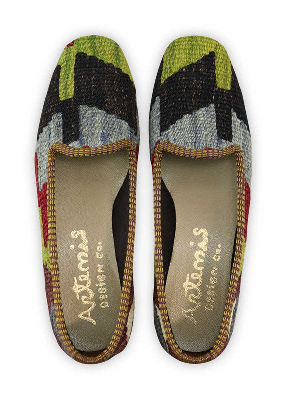 Artemis Design Co. Women's Loafers exude a bold and stylish charm with a captivating color palette of green, black, blue, maroon, purple, and white. Meticulously crafted, these loafers seamlessly blend vibrant and classic tones, creating a versatile and eye-catching footwear option. The dynamic interplay of colors, from the deep greens and maroons to the cool blues and purples, complemented by the classic black and crisp white, adds a touch of modern flair. (Front View)