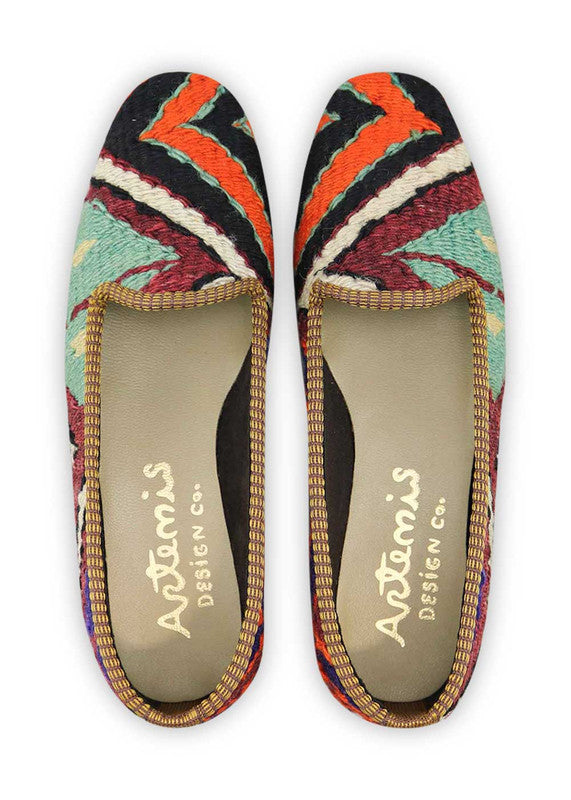 The Artemis Design & Co Women's Loafer is a striking and chic footwear choice that boasts a captivating color palette. Featuring vibrant shades of red-orange, black, purple, mint green, maroon, and white, these loafers make a bold fashion statement. Designed with meticulous attention to style and comfort, they effortlessly enhance your attire for a wide range of occasions. (Front View)