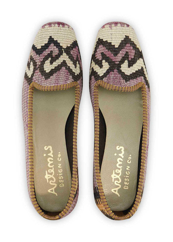 The Artemis Design & Co Women's Loafer is a stylish and versatile footwear option that combines a vibrant color palette. These loafers feature a unique blend of purple, black, white, and orange, creating a striking and eye-catching design. (Front View)
