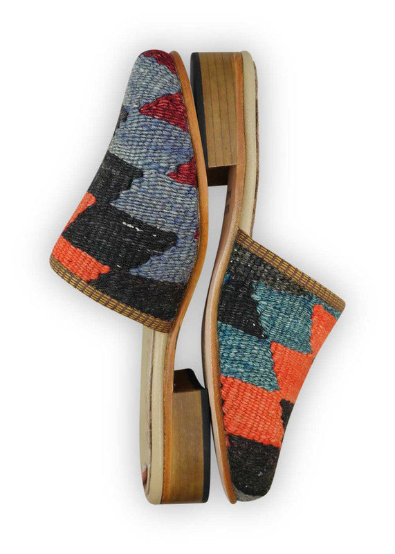 The Artemis Women's Slides exhibit a captivating color combination of red, blue, black, red orange, and dark grey. These slides offer a lively interplay of bold and classic tones, creating a dynamic and versatile look. Whether you're unwinding at home or stepping out for a casual outing, these slides are the perfect choice. (Side View)
