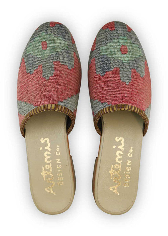 The Artemis Women's Slides showcase a stylish color combination of grey and red. These slides offer a subtle yet eye-catching blend of neutral and bold tones, creating a versatile and fashionable look. Whether you're relaxing at home or stepping out for a casual outing, these slides are the perfect choice. (Front View)