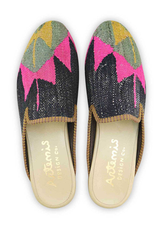 These slippers feature an eye-catching color combination of mustard, grey, fuschia, and black. The kilim-inspired design adds a touch of uniqueness and sophistication to your look. (Front View)