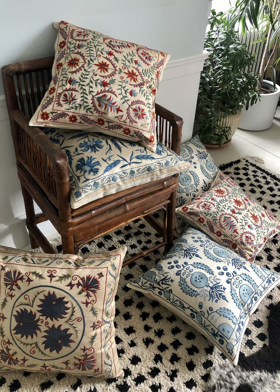 pile-of-suzani-pillows-on-bamboo-chair-and-floor