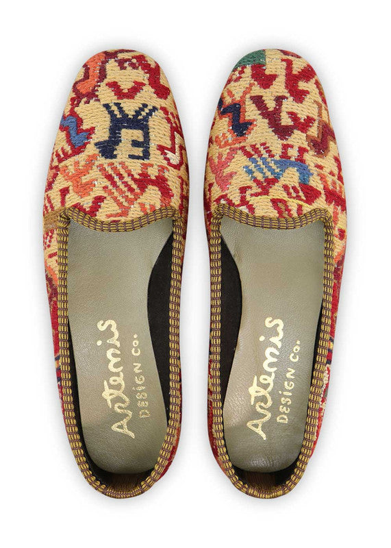 These loafers feature a harmonious blend of colors that create a visually stunning and vibrant design.  The red and red orange hues inject a burst of energy and passion, while the teal and blue shades bring a cool and refreshing element to the palette. The pink adds a touch of femininity and playfulness, while the off white and light brown tones provide a neutral and versatile backdrop. (Front View)
